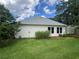 View of the home's backyard with healthy green grass, mature landscaping, and a light colored house at 333 Etoawha Vly, Woodstock, GA 30189