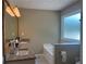 Bathroom featuring granite countertop with dual sinks, a large mirror, and a soaking tub at 333 Etoawha Vly, Woodstock, GA 30189