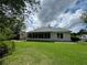 The home's back exterior features a bright sunroom, a well-kept lawn, and mature trees at 333 Etoawha Vly, Woodstock, GA 30189