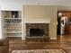Living room featuring a stone fireplace with a white mantle, complementing built-in shelving, and hardwood floors at 333 Etoawha Vly, Woodstock, GA 30189