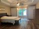 A well-lit main bedroom featuring hardwood floors and a tray ceiling at 333 Etoawha Vly, Woodstock, GA 30189