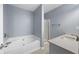 Bathroom featuring a soaking tub, glass-enclosed shower, and quartz vanity top at 3737 Town Square Nw Cir # 6, Kennesaw, GA 30144