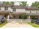 Exterior showcasing townhome's facade, driveway, landscaping, and charming white picket fence at 3737 Town Square Nw Cir # 6, Kennesaw, GA 30144