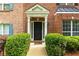 Beautiful brick home featuring a classic entrance with a dark door, green shrubbery, and light trim at 3737 Town Square Nw Cir # 6, Kennesaw, GA 30144