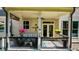 Relaxing covered porch area is furnished for seating and decorated with hanging flower baskets at 10140 Grandview Sq, Duluth, GA 30097