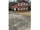 Red brick two-story home with a driveway and a partially attached garage at 1046 Sans Souci Way, Clarkston, GA 30021