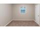 Empty bedroom showcasing neutral walls, carpet floors, and a window for natural light at 2047 Cliffton Ter, Snellville, GA 30039