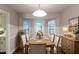 Charming dining area with a wood table, decorative chandelier, and natural light from bay windows at 2047 Cliffton Ter, Snellville, GA 30039