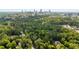 An aerial view overlooking mature trees and several houses with Atlanta's skyline in the distance on a bright sunny day at 3415 Habersham Nw Rd, Atlanta, GA 30305