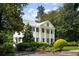A stately white home features classic architectural details, black shutters, and a meticulously landscaped front yard for curb appeal at 3415 Habersham Nw Rd, Atlanta, GA 30305