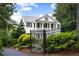 A stately white home with a black iron fence is surrounded by lush greenery offering classic charm and curb appeal at 3415 Habersham Nw Rd, Atlanta, GA 30305