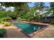 A beautiful rectangular pool with brick trim is surrounded by patio seating and lush landscaping in this serene backyard oasis at 3415 Habersham Nw Rd, Atlanta, GA 30305
