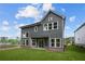Exterior view of home featuring gray siding, white trim, large windows, and level, grassy backyard at 4445 Beechnut Circle, Cumming, GA 30028