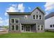 Exterior view of home featuring gray siding, white trim, large windows, and level, grassy backyard at 4445 Beechnut Circle, Cumming, GA 30028