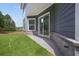 Exterior view of home featuring sliding glass door, gray siding, and level, grassy backyard at 4445 Beechnut Circle, Cumming, GA 30028