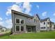 Exterior view of home featuring gray siding, white trim, large windows, and level, grassy backyard at 4445 Beechnut Circle, Cumming, GA 30028