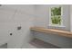 Bright laundry room offers a functional workspace with a built-in shelf and shelving unit at 4445 Beechnut Circle, Cumming, GA 30028