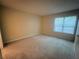 A large room with neutral walls, carpet, and one window that provides natural light at 1612 Huntingdon, Atlanta, GA 30350
