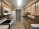 Well-lit kitchen featuring a white refrigerator and oven, granite countertops, and tiled floors at 1612 Huntingdon, Atlanta, GA 30350