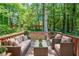 Outdoor deck featuring comfortable seating, a glass table, and serene wooded views at 2242 Cherokee Valley Cir, Lithonia, GA 30058
