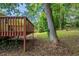 Lush backyard with mature trees, a wooden deck, and a partial view of the yellow house at 2242 Cherokee Valley Cir, Lithonia, GA 30058