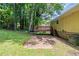 Backyard with mature trees, a wooden deck, and a partial view of the yellow house at 2242 Cherokee Valley Cir, Lithonia, GA 30058