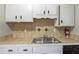 The kitchen area showcases white cabinets, tile backsplash, a stainless steel sink and a fire extinguisher at 2242 Cherokee Valley Cir, Lithonia, GA 30058