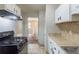 Well-lit kitchen featuring white cabinets, tiled countertops, and modern appliances at 2242 Cherokee Valley Cir, Lithonia, GA 30058