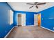 Spacious bedroom with carpet flooring, ceiling fan, closet and bright blue walls at 573 Hambrick Sq, Stone Mountain, GA 30083