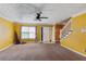Inviting living area with a ceiling fan, textured ceiling, and stairs leading to upper level at 573 Hambrick Sq, Stone Mountain, GA 30083