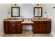 Dual vanities with dark wood cabinetry and travertine countertops in a spacious bathroom at 1292 Lenox Park Ne Blvd, Brookhaven, GA 30319