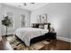 Bright bedroom with two windows, king bed, hardwood floors, and a decorative rug at 1292 Lenox Park Ne Blvd, Brookhaven, GA 30319
