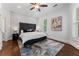 Cozy bedroom with a tufted headboard, large window, and hardwood floors at 1292 Lenox Park Ne Blvd, Brookhaven, GA 30319