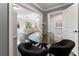 Inviting dining area flowing into a living space offers a glass table, modern seating, and a stylish ambiance at 1292 Lenox Park Ne Blvd, Brookhaven, GA 30319
