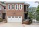 Charming two-story brick home with an attached two car garage and mature trees in the background at 1292 Lenox Park Ne Blvd, Brookhaven, GA 30319