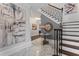 Bright foyer with marble floors, decorative art and table, staircase with wood railing and treads at 1292 Lenox Park Ne Blvd, Brookhaven, GA 30319