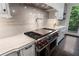Close-up of a kitchen featuring stainless steel range, stone backsplash and countertops, and white cabinets at 1292 Lenox Park Ne Blvd, Brookhaven, GA 30319