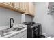 Well-equipped laundry room with a sink, modern washer and dryer, and overhead cabinets at 1292 Lenox Park Ne Blvd, Brookhaven, GA 30319
