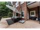 Spacious patio with outdoor seating, a grill, and a view of the landscaped backyard of a brick house at 1292 Lenox Park Ne Blvd, Brookhaven, GA 30319
