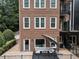 Brick home's rear exterior with a cozy outdoor patio area featuring comfortable seating and lush landscaping at 1292 Lenox Park Ne Blvd, Brookhaven, GA 30319