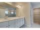 Modern bathroom featuring a large mirror, dual white vanities, glass shower, and neutral tile flooring at 251 Arnewood Cir, Mcdonough, GA 30253