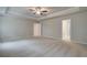 Large bedroom features neutral walls, carpeted floors, a trey ceiling with a ceiling fan, and doorways at 251 Arnewood Cir, Mcdonough, GA 30253