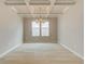 Neutral dining room featuring a coffered ceiling and modern light fixture over wood-look floors at 251 Arnewood Cir, Mcdonough, GA 30253