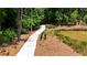 Inviting walking path leading through a wooded area, adjacent to a pond, promoting outdoor enjoyment at 362 Olmstead Way # 23, Alpharetta, GA 30022