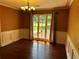 Dining room features hardwood flooring, detailed wainscoting, and large picture window at 512 Ollas Walk, Mcdonough, GA 30252