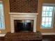 Red brick fireplace with white wood trim and large mantle between two windows at 512 Ollas Walk, Mcdonough, GA 30252