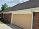 Attached two-car garage with a painted door complementing the brick exterior and surrounded by green foliage at 512 Ollas Walk, Mcdonough, GA 30252