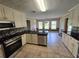 Spacious kitchen with white cabinetry, modern stainless steel appliances, and granite counters at 512 Ollas Walk, Mcdonough, GA 30252