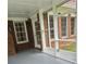 Covered patio with open screened walls that leads to backyard, painted concrete floor and brick walls at 512 Ollas Walk, Mcdonough, GA 30252