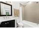 Bathroom featuring vanity with dark cabinets, white countertop, framed mirror and tiled shower at 1103 Briar Cove Ne Cir, Atlanta, GA 30329